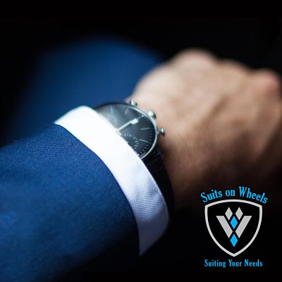 A watch on someone's wrist with a blue suit - cropped